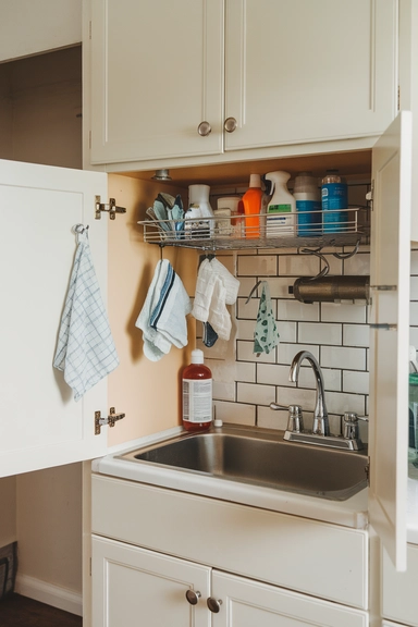 23 Rental Kitchen Organization Ideas For Real Homes 7 Hang a Tension Rod for Under-Sink Organization
