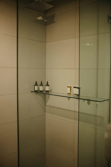 Glass Shelf Along the Back Wall of a Walk-In Shower